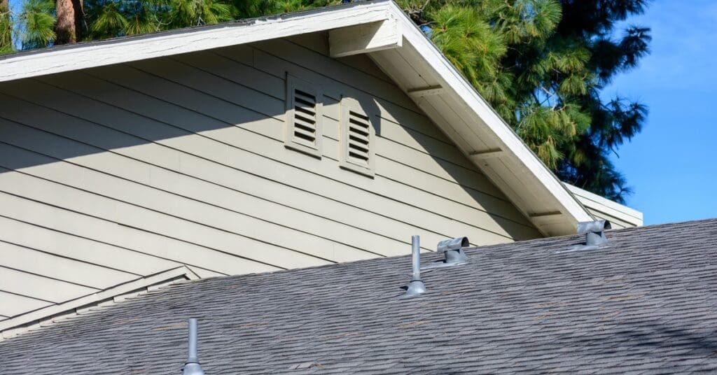 The siding of a residential home contains two vents near the roof to help circulate air from the home's attic.